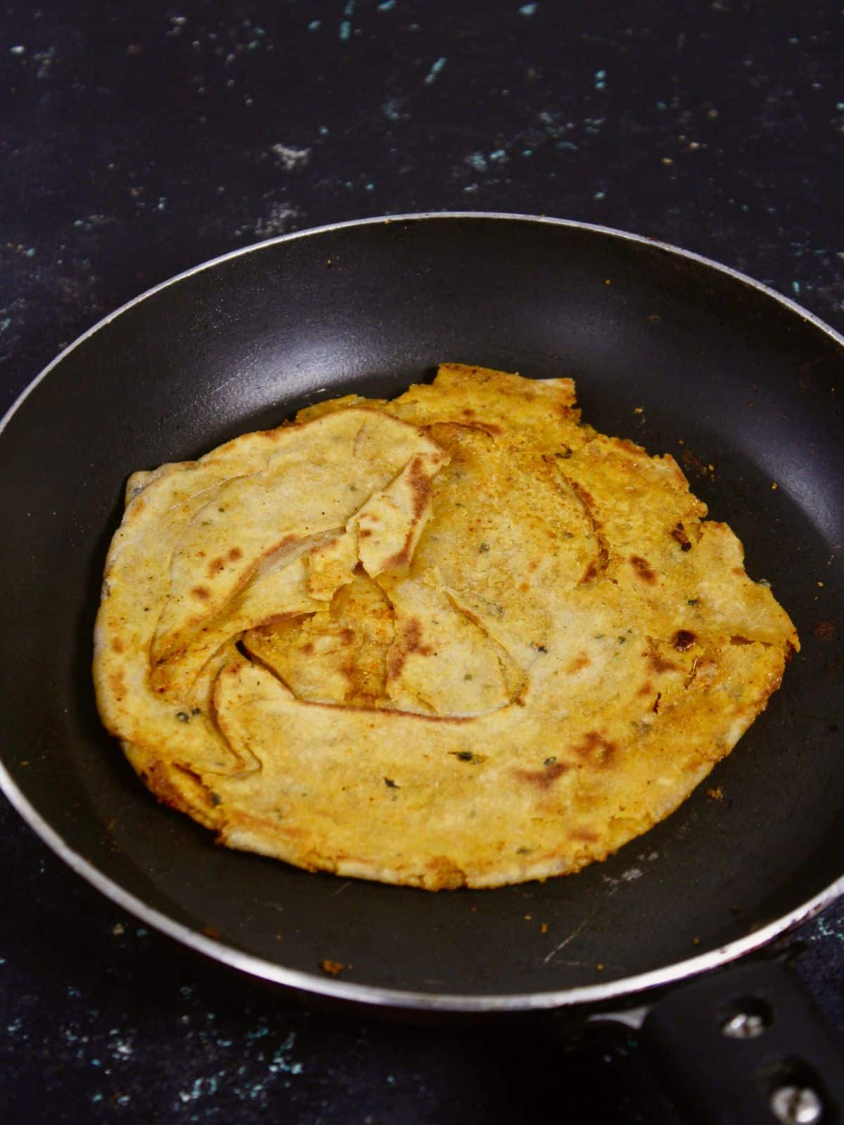 flip the kulcha to fry it on another side 