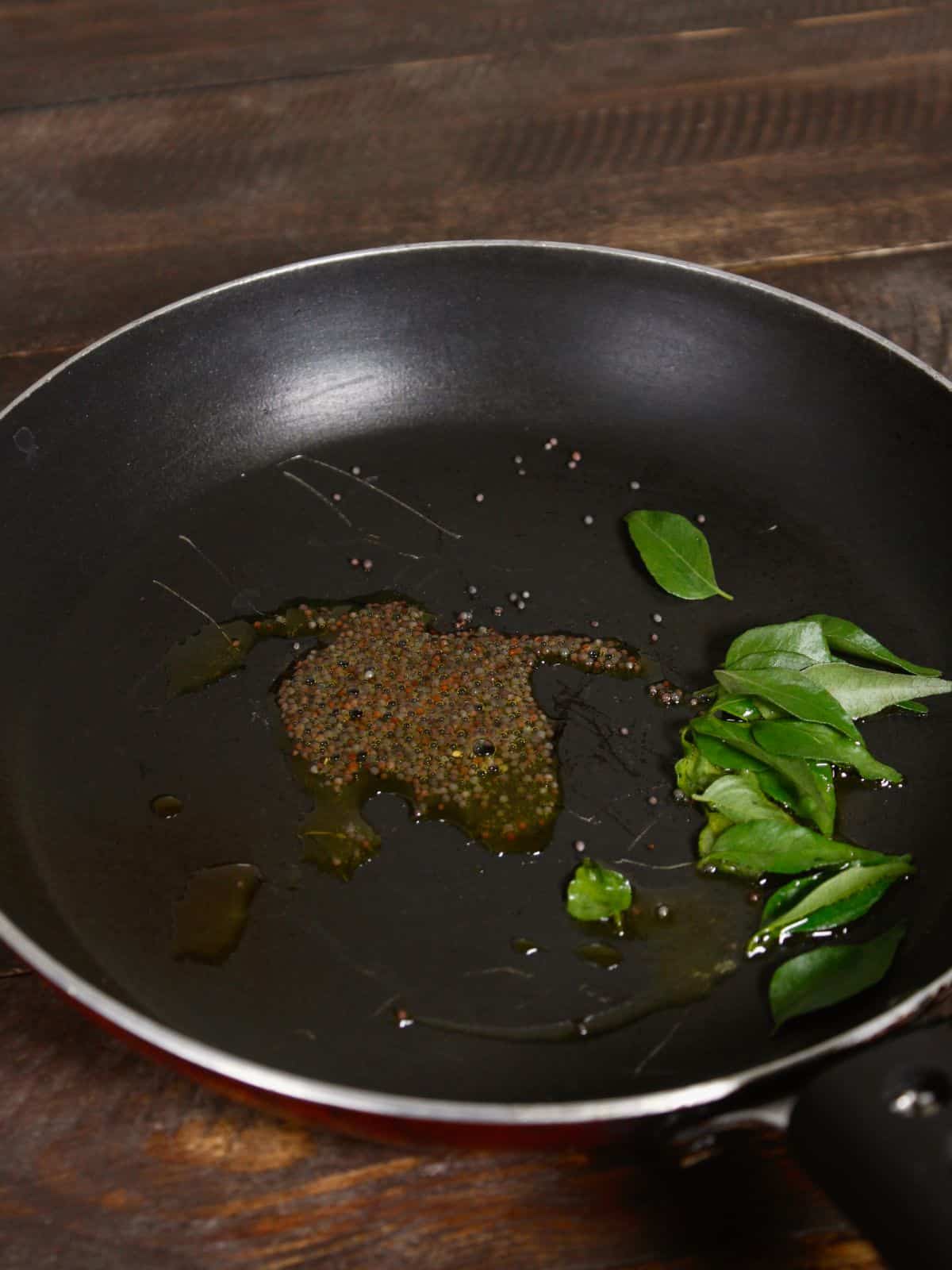 mustard seeds and curry leaves in a pan 