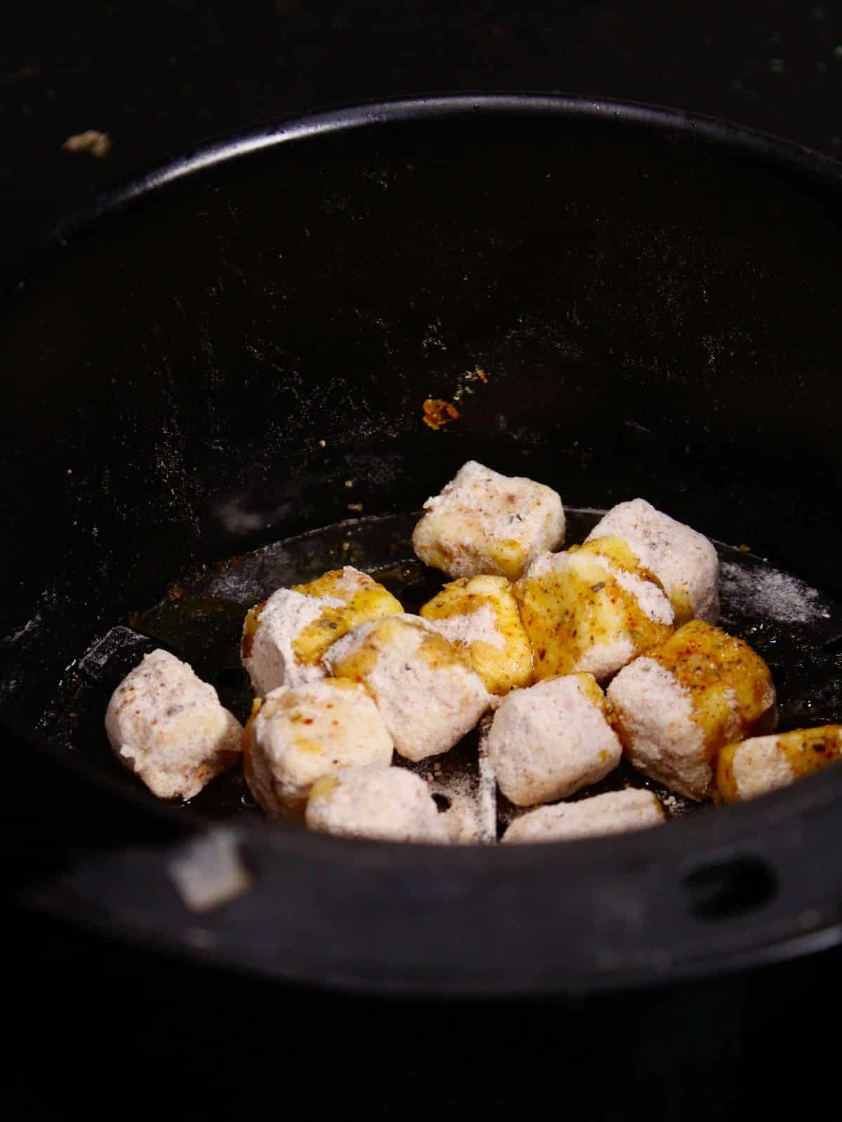 transfer the coated paneer into the air fryer and air fry it 