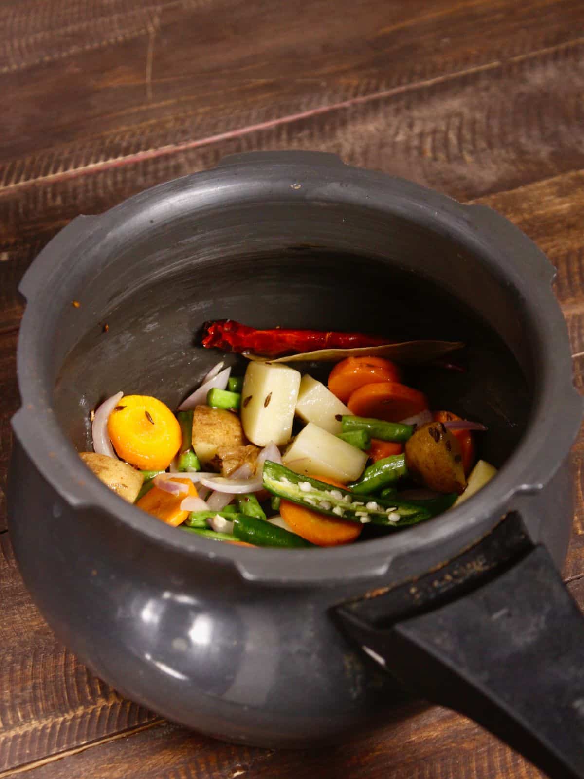 add slit green chilies to the pot 