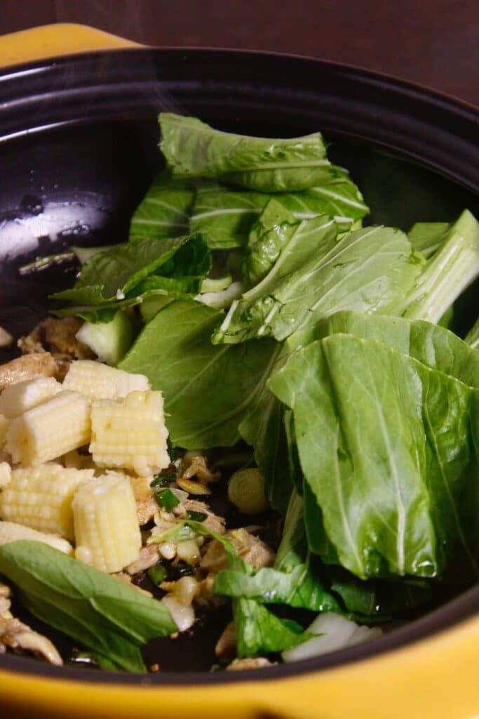 add bok choy and baby corn to the pan and mix well 