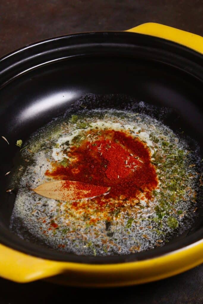 add tomato paste and red chili powder in the pan and saute 