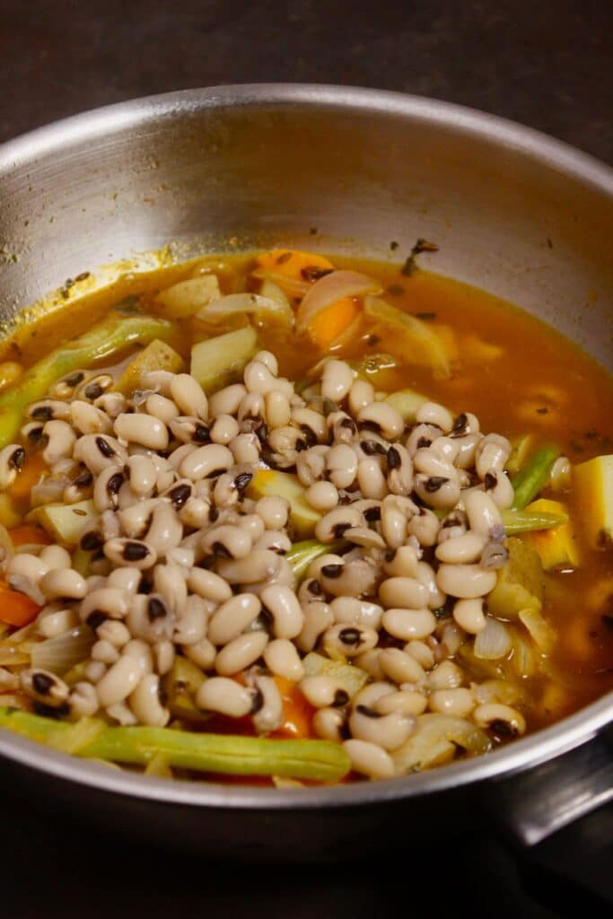add soaked black eyed beans to the pan and mix well 