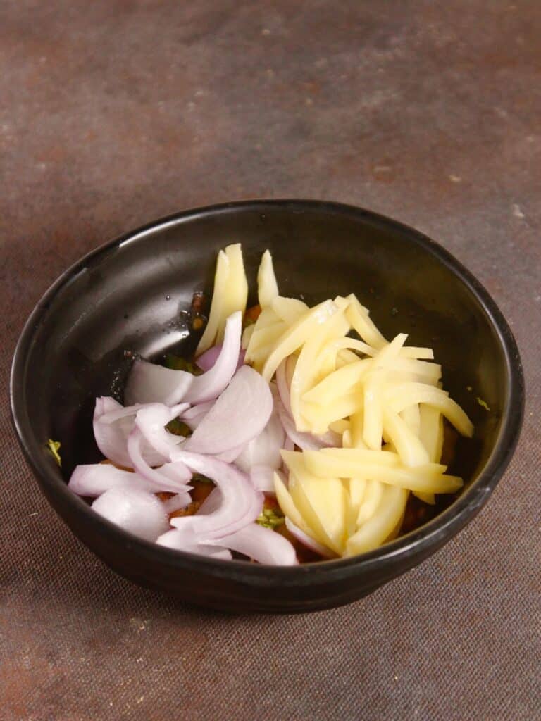 add sliced onions and potatoes to the bowl 