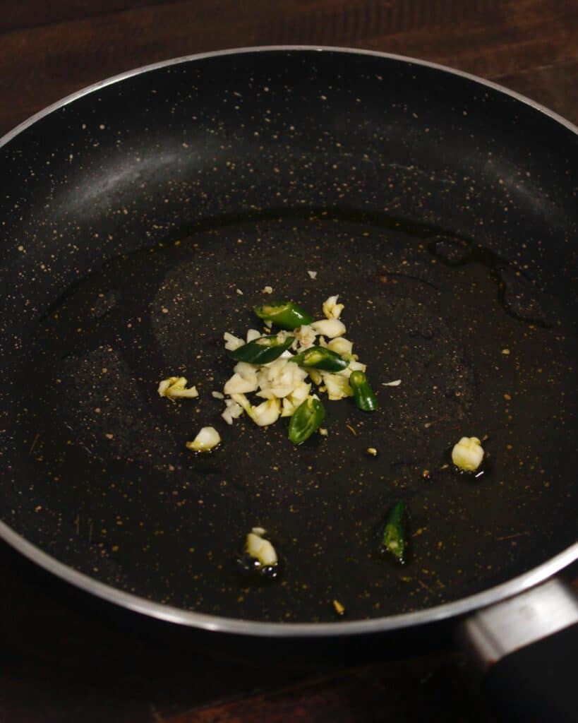 take chopped onions and green chilies in a pan 