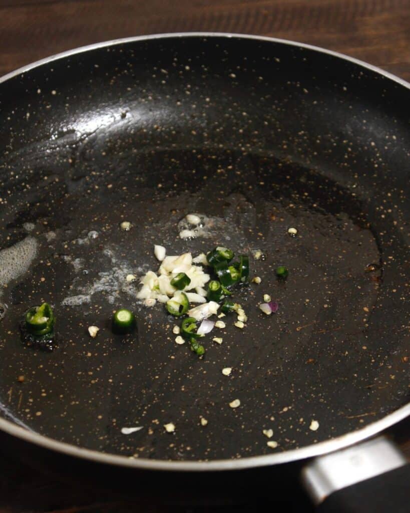 add chopped garlic and green chillies in a pan  