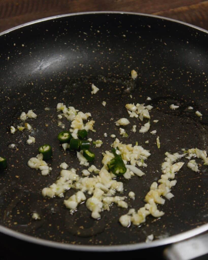add minced garlic and chillies with butter on a pan 