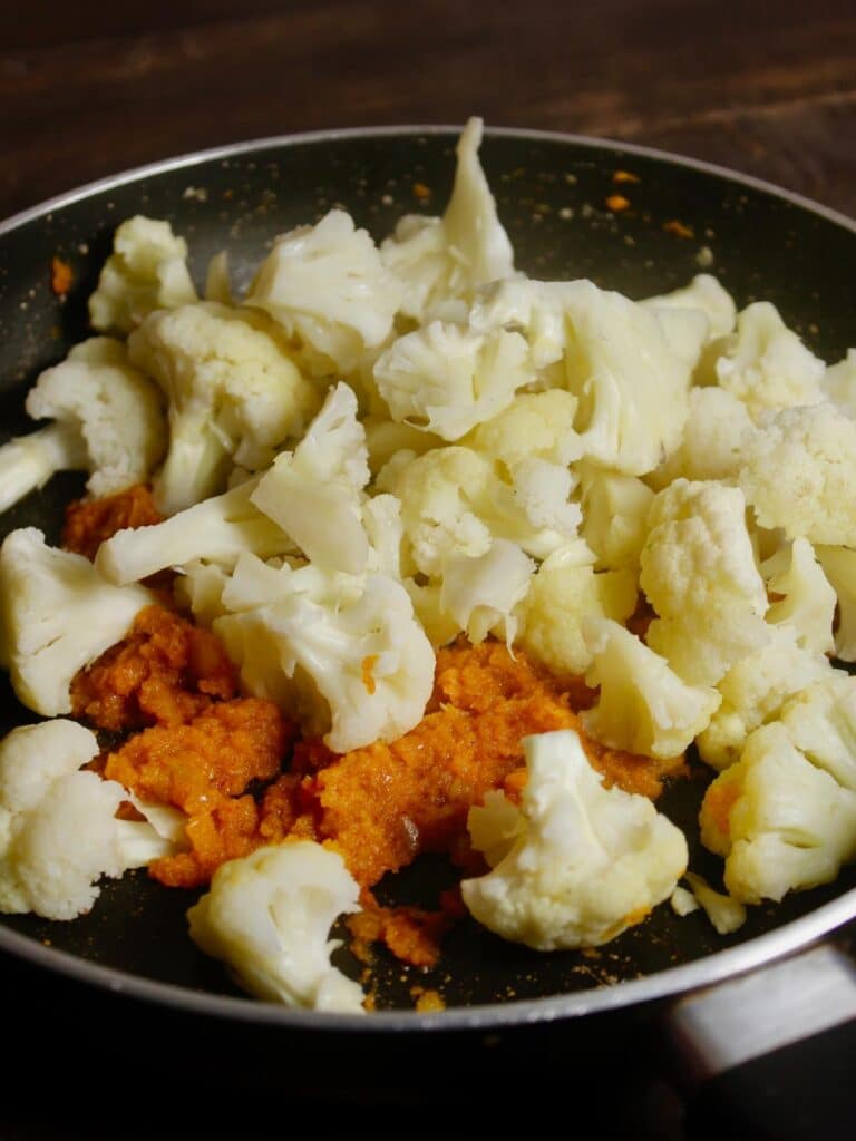 add cauliflower florets to the pan and mix well