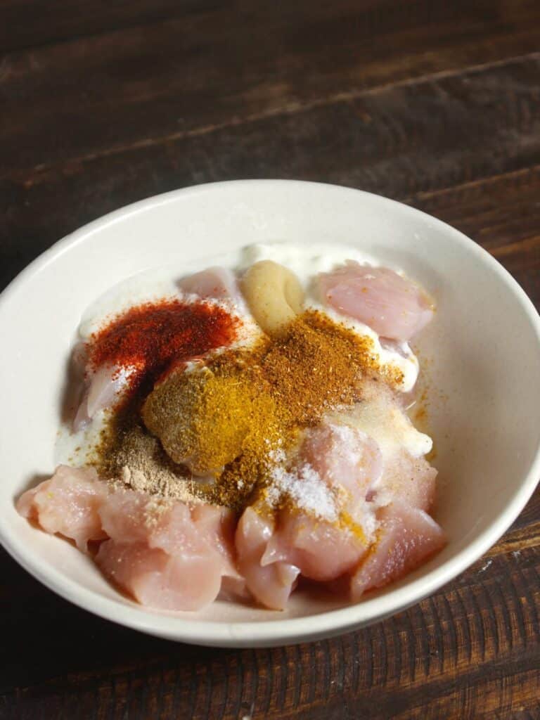 chicken pieces with powdered spices in a bowl