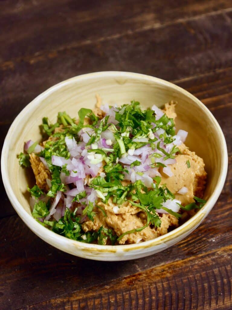 add chopped onions, green chilies and coriander with dal and chicken mixture in a bowl 