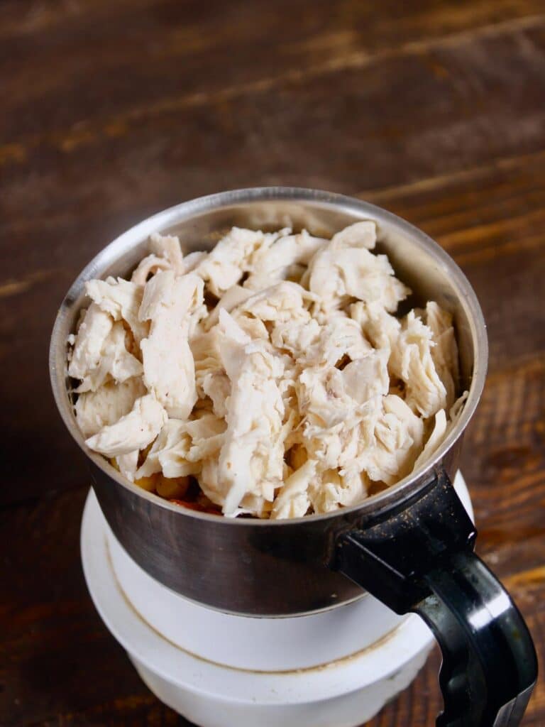 take boiled chicken pieces into the blender and blend it 