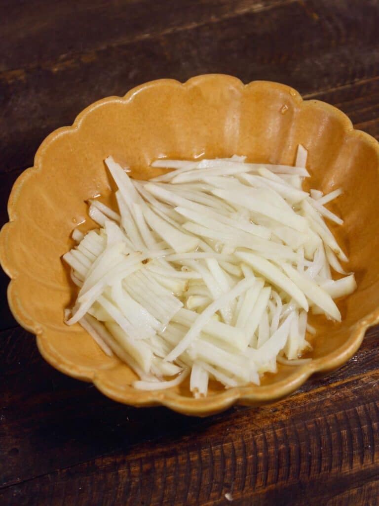 soak potato slices in water in a bowl  