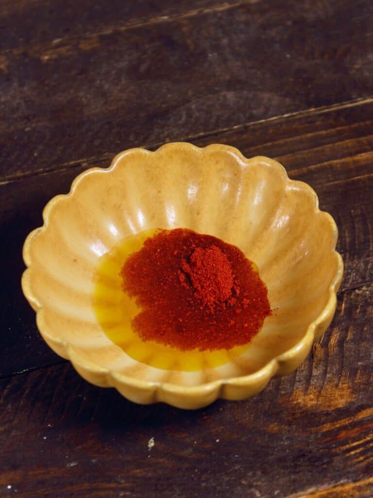 mustard oil, red chili powder in a small bowl 